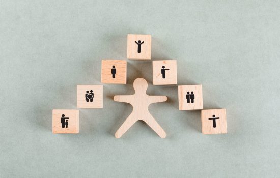Success employee concept with wooden human, blocks with icons on sage color background flat lay. horizontal image